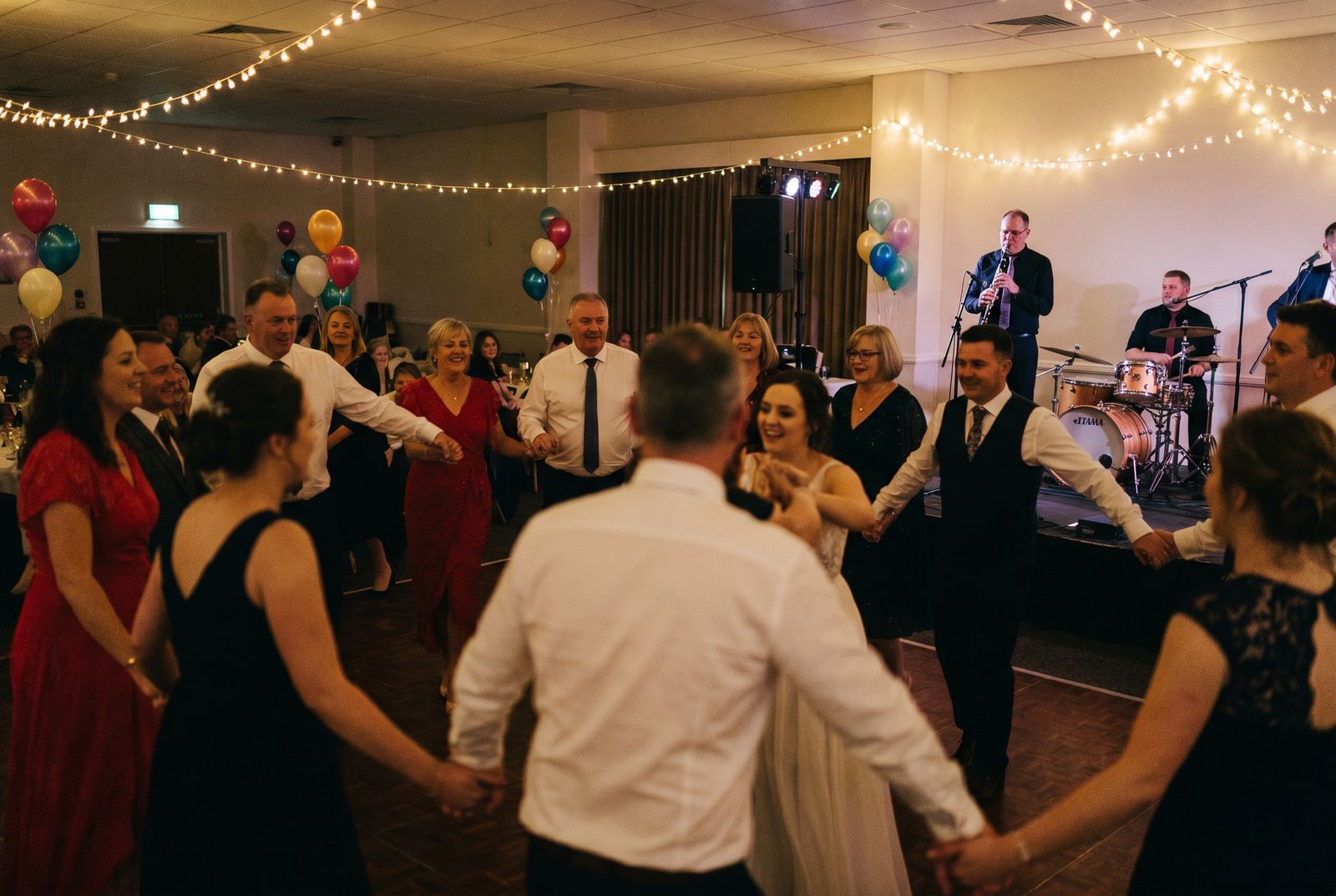Gäste tanzen bei einer albanischen Hochzeit im Kreis Hand in Hand vor der Live-Band