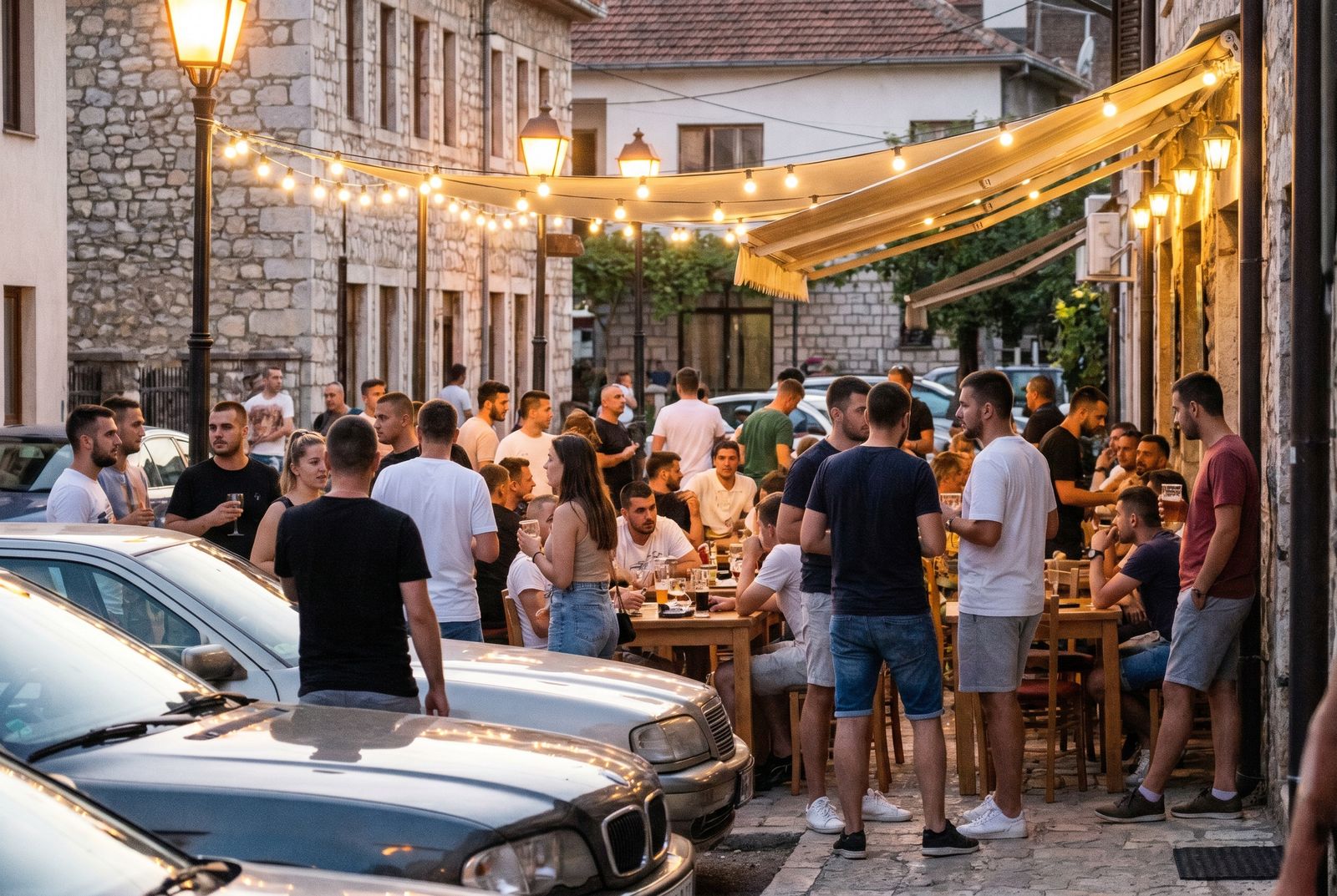 Junge Leute sitzen abends auf einer belebten Café-Terrasse im Kosovo im Sommer